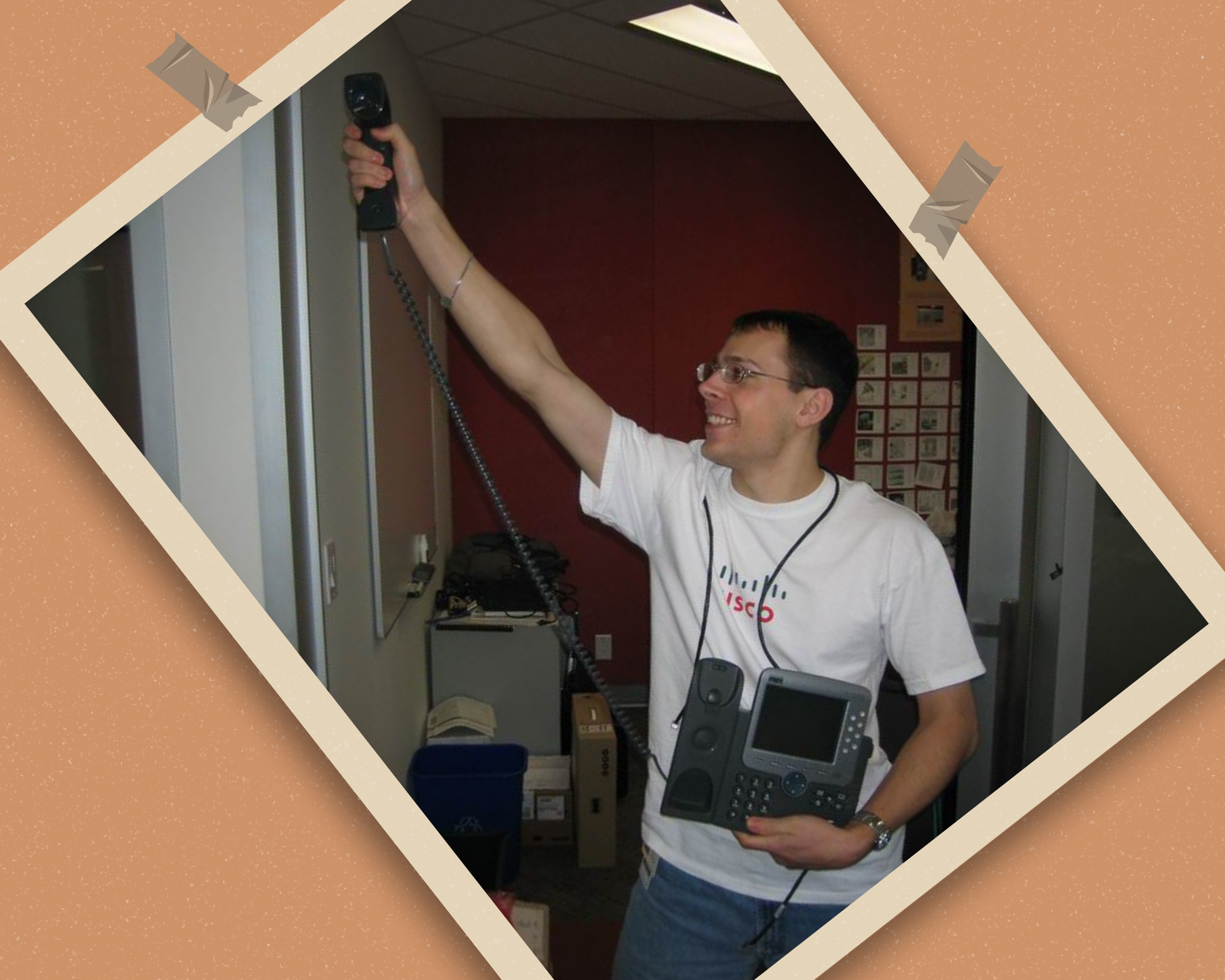 SuperNeil Image of Neil holding up a Cisco IP Phone in a Superman pose.